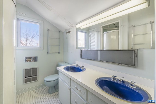 bathroom featuring heating unit, vanity, vaulted ceiling, tile patterned floors, and toilet