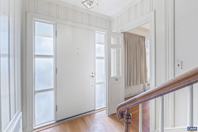 foyer with crown molding and light wood-type flooring