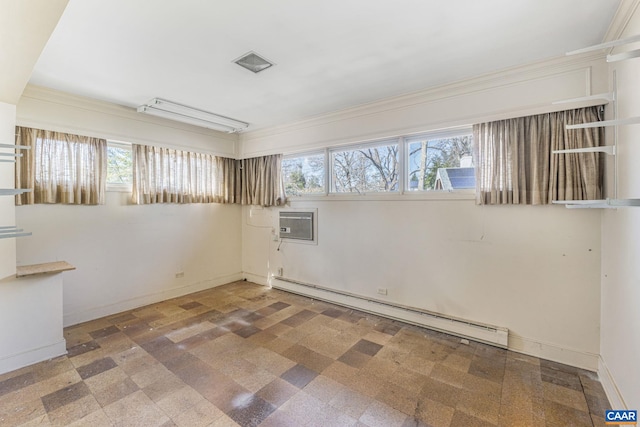 spare room with a wall mounted air conditioner, a healthy amount of sunlight, and baseboard heating