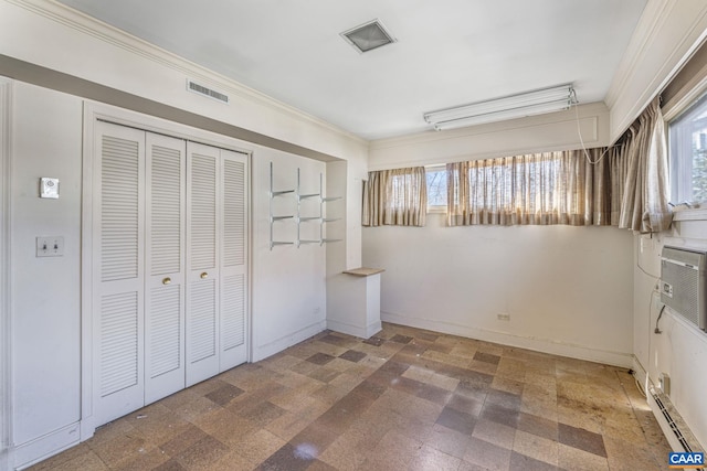 unfurnished bedroom featuring multiple windows, ornamental molding, and a closet