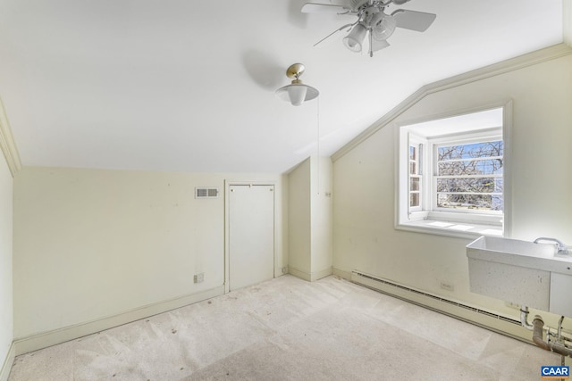 bonus room with sink, ceiling fan, a baseboard heating unit, light carpet, and vaulted ceiling