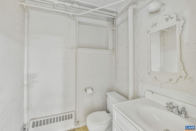 bathroom with radiator heating unit, toilet, and vanity