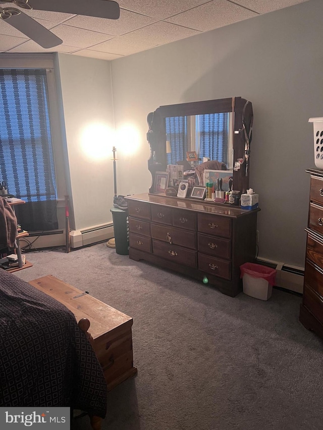 bedroom featuring a baseboard radiator, carpet flooring, and a drop ceiling