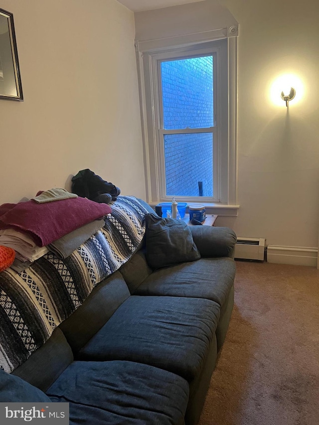 carpeted living room featuring a baseboard heating unit