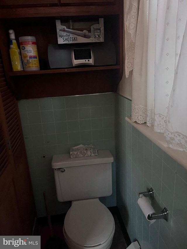 bathroom with tile walls and toilet