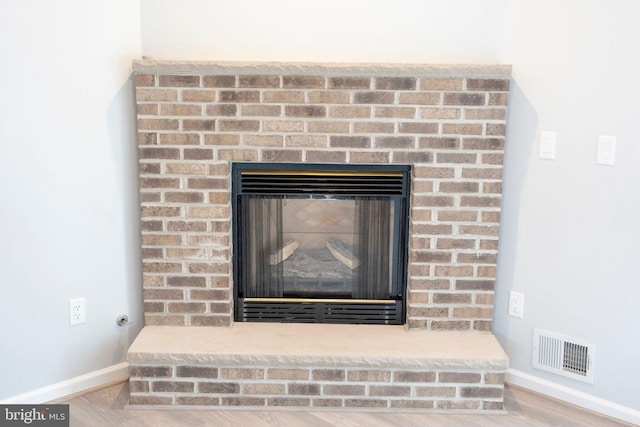 room details with hardwood / wood-style floors and a fireplace