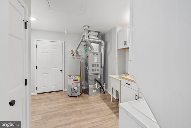 utility room with heating unit, sink, and water heater