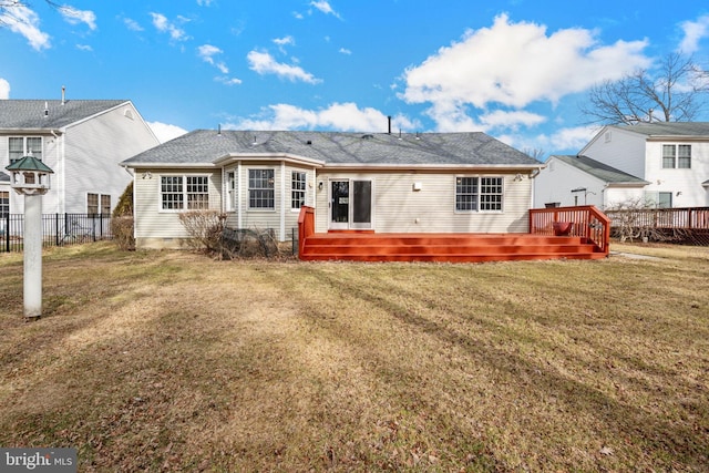 rear view of house featuring a wooden deck and a yard