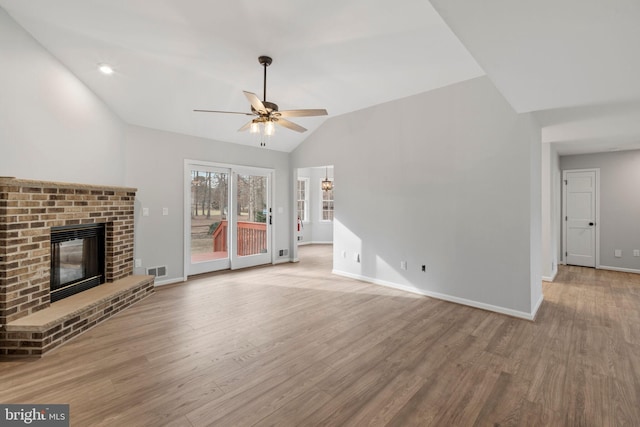 unfurnished living room featuring light hardwood / wood-style flooring, a fireplace, ceiling fan, and vaulted ceiling