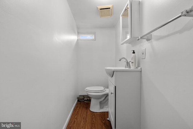 bathroom featuring vanity, hardwood / wood-style flooring, and toilet