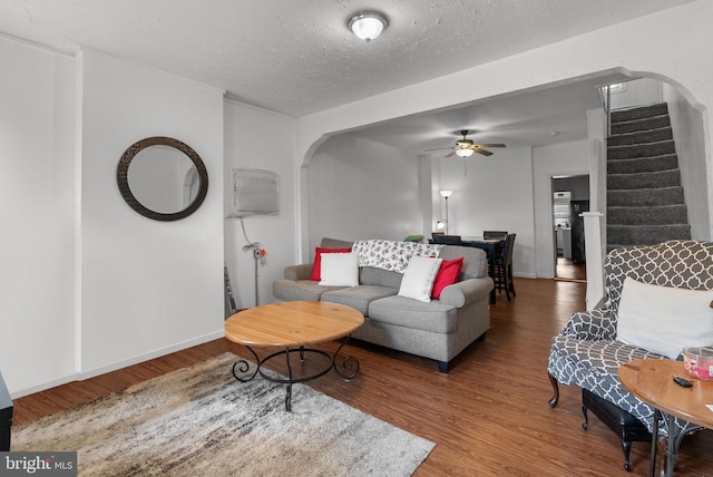 living room with hardwood / wood-style floors, a textured ceiling, and ceiling fan