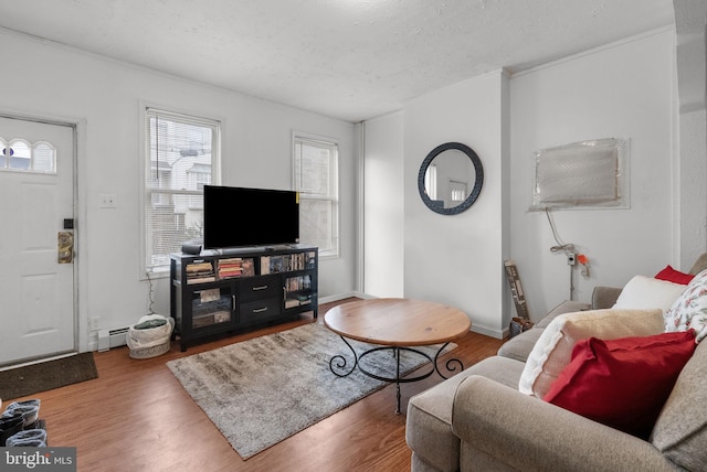 living room with hardwood / wood-style flooring, a baseboard radiator, and a textured ceiling