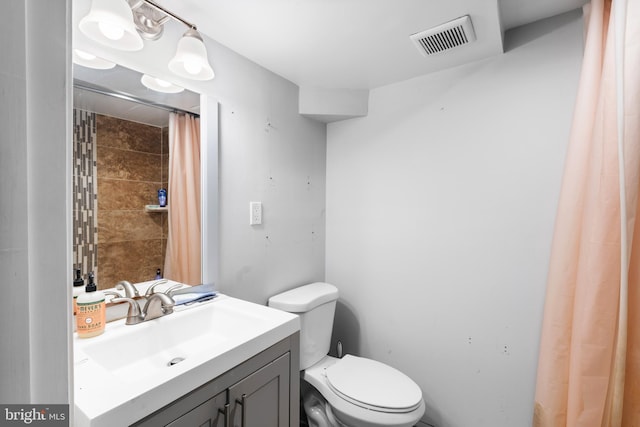 bathroom featuring toilet, vanity, and walk in shower