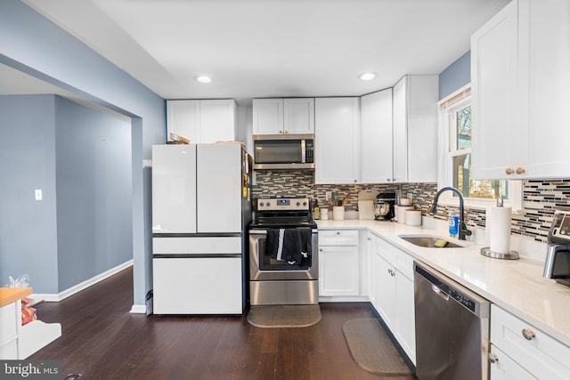 kitchen with sink, stainless steel appliances, dark hardwood / wood-style flooring, white cabinets, and decorative backsplash