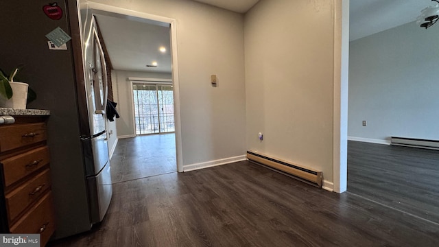 interior space featuring dark hardwood / wood-style flooring, a baseboard radiator, and stainless steel refrigerator