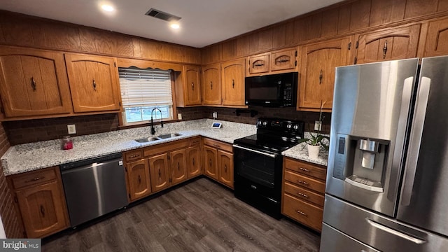 kitchen with light stone counters, sink, black appliances, and dark hardwood / wood-style floors