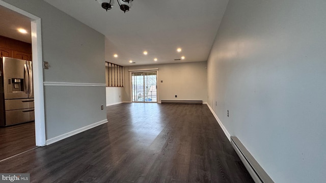 unfurnished living room featuring a baseboard heating unit and dark wood-type flooring