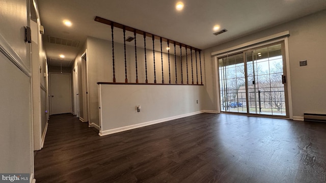 unfurnished room featuring dark hardwood / wood-style flooring and baseboard heating