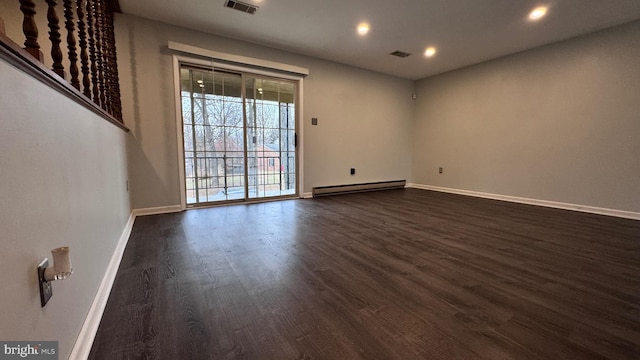 unfurnished room with baseboard heating and dark wood-type flooring