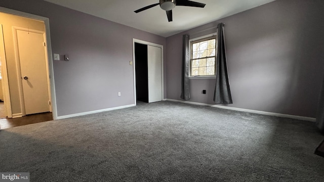 unfurnished bedroom with dark carpet, a closet, and ceiling fan