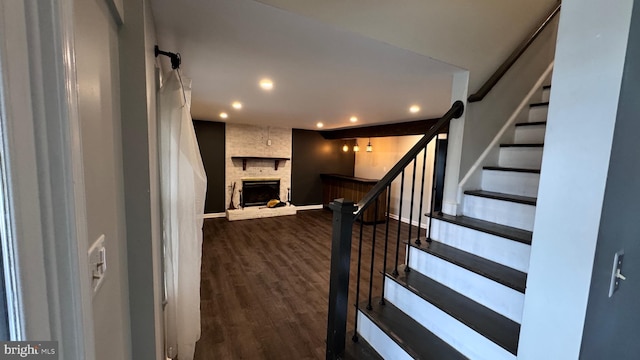 stairway featuring a fireplace and wood-type flooring