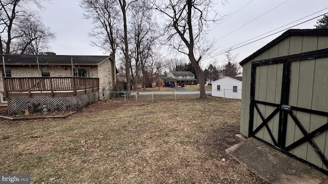 view of yard featuring a wooden deck and a storage unit