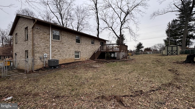 view of side of property with central AC unit, a yard, a storage unit, and a deck