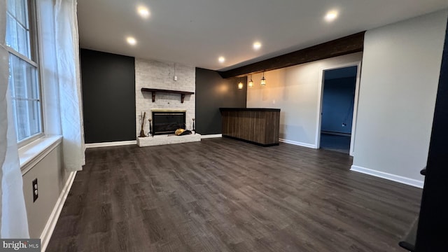 unfurnished living room featuring dark hardwood / wood-style floors and a large fireplace