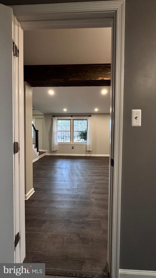 corridor with beam ceiling and dark wood-type flooring