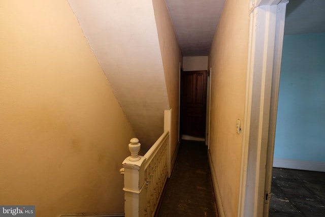 hallway featuring an upstairs landing and baseboards