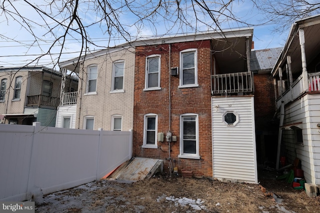 back of house with fence and brick siding