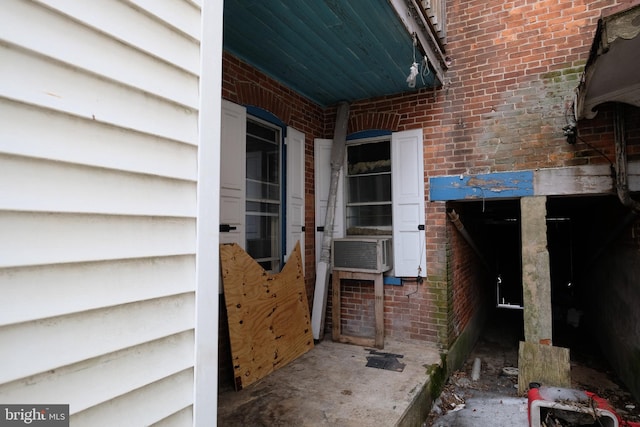 doorway to property featuring cooling unit and brick siding