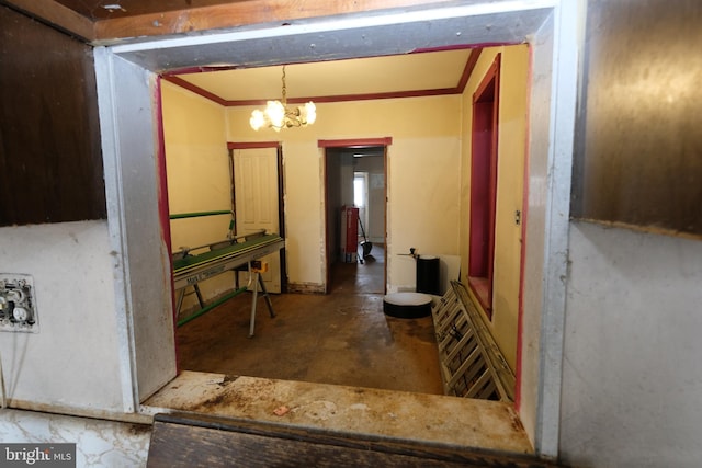 corridor featuring a chandelier and concrete flooring