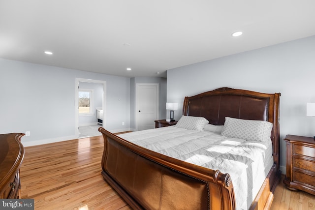 bedroom with ensuite bath and light hardwood / wood-style flooring