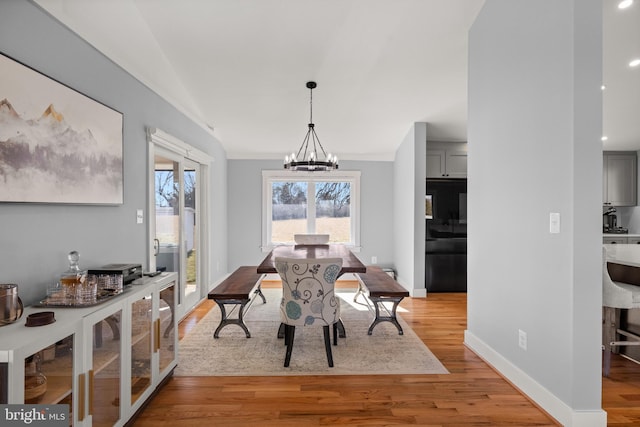 dining space with an inviting chandelier and light hardwood / wood-style floors