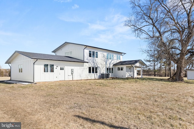 back of property with a yard and central AC unit