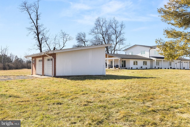 back of property with a yard and a garage