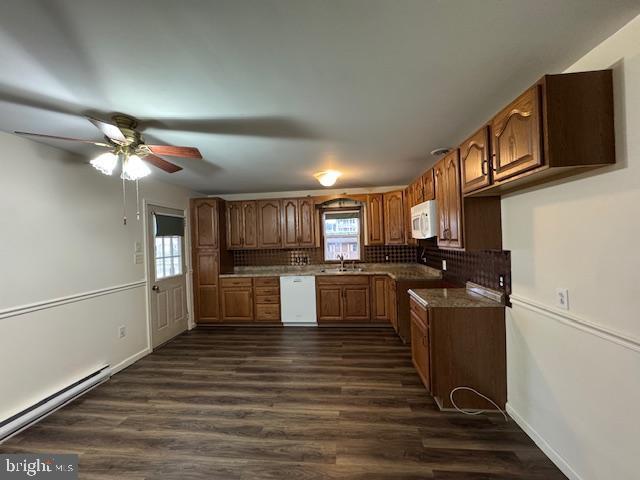 kitchen with sink, white appliances, dark hardwood / wood-style flooring, decorative backsplash, and a baseboard radiator