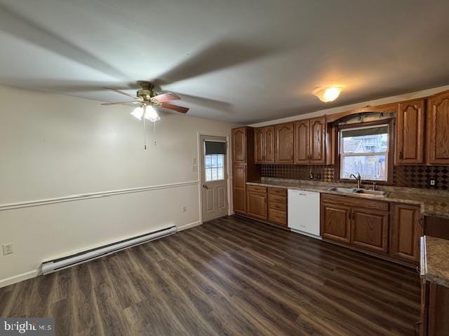 kitchen with a wealth of natural light, dishwasher, sink, a baseboard heating unit, and dark wood-type flooring