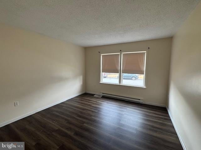 unfurnished room with dark wood-type flooring, a baseboard radiator, and a textured ceiling