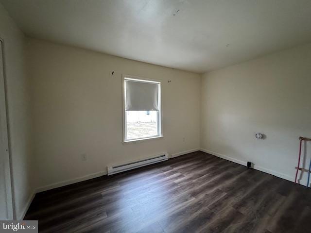 unfurnished room with dark hardwood / wood-style floors and baseboard heating