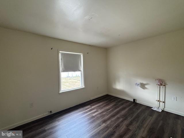 unfurnished room with dark hardwood / wood-style flooring