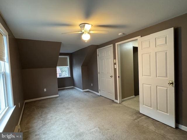 additional living space with ceiling fan, lofted ceiling, and light colored carpet