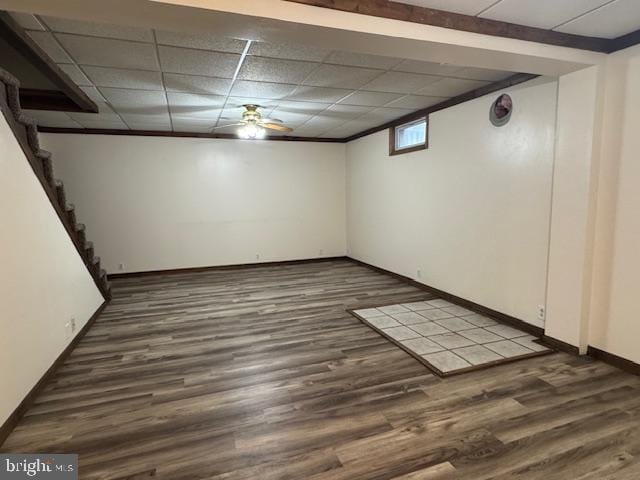 basement with a drop ceiling and dark wood-type flooring