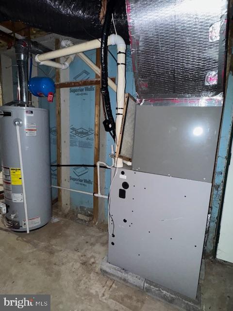 utility room with heating unit and gas water heater