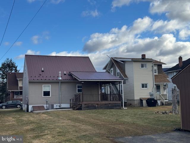 rear view of property with a porch and a yard