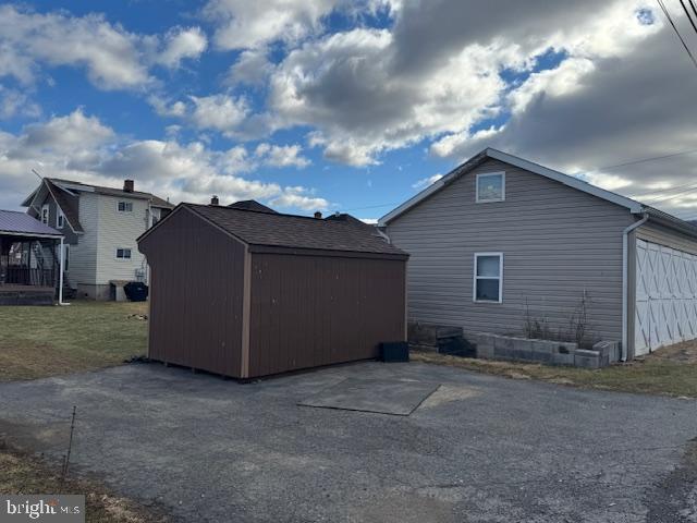 view of home's exterior with a shed, a garage, and a lawn