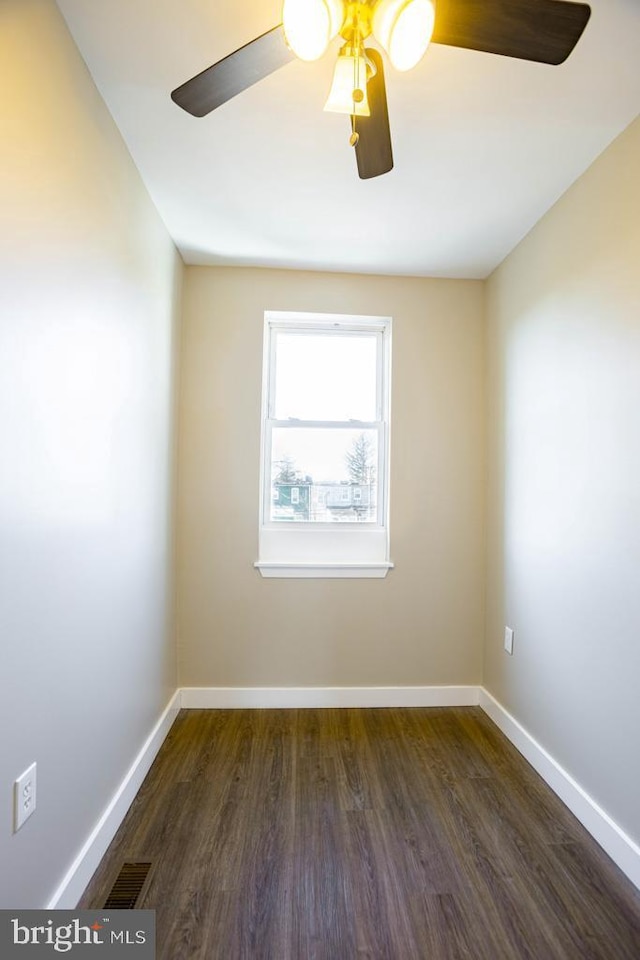 spare room with dark hardwood / wood-style flooring and ceiling fan