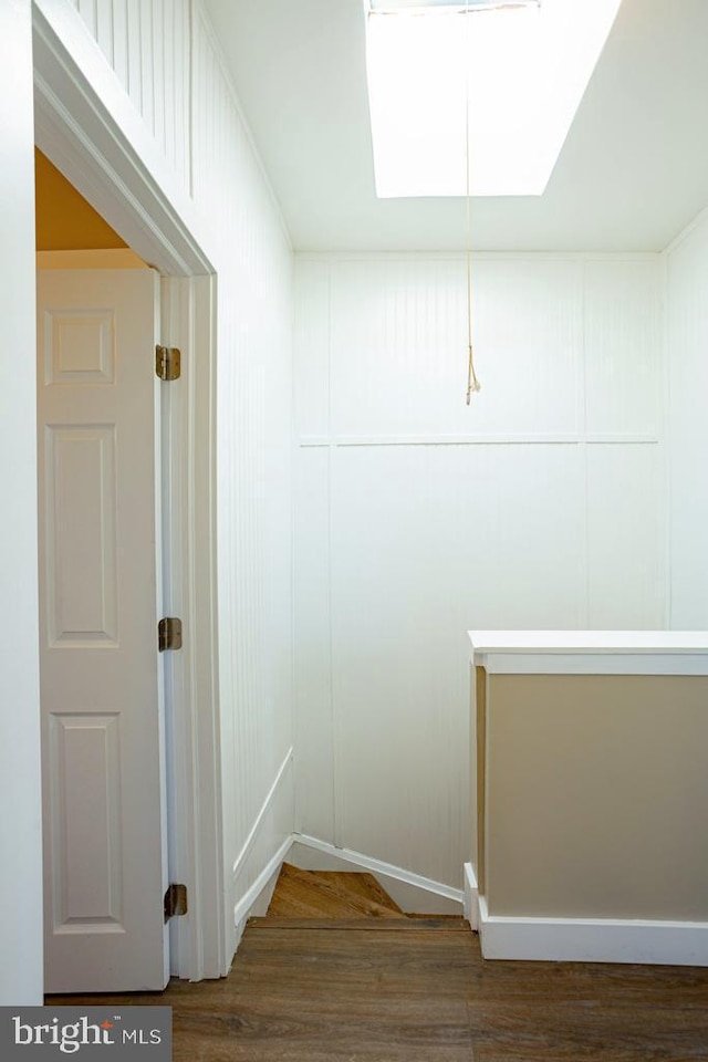 interior space featuring dark hardwood / wood-style flooring and a skylight