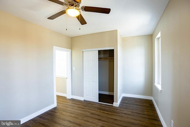 unfurnished bedroom featuring dark wood-type flooring, ceiling fan, and a closet